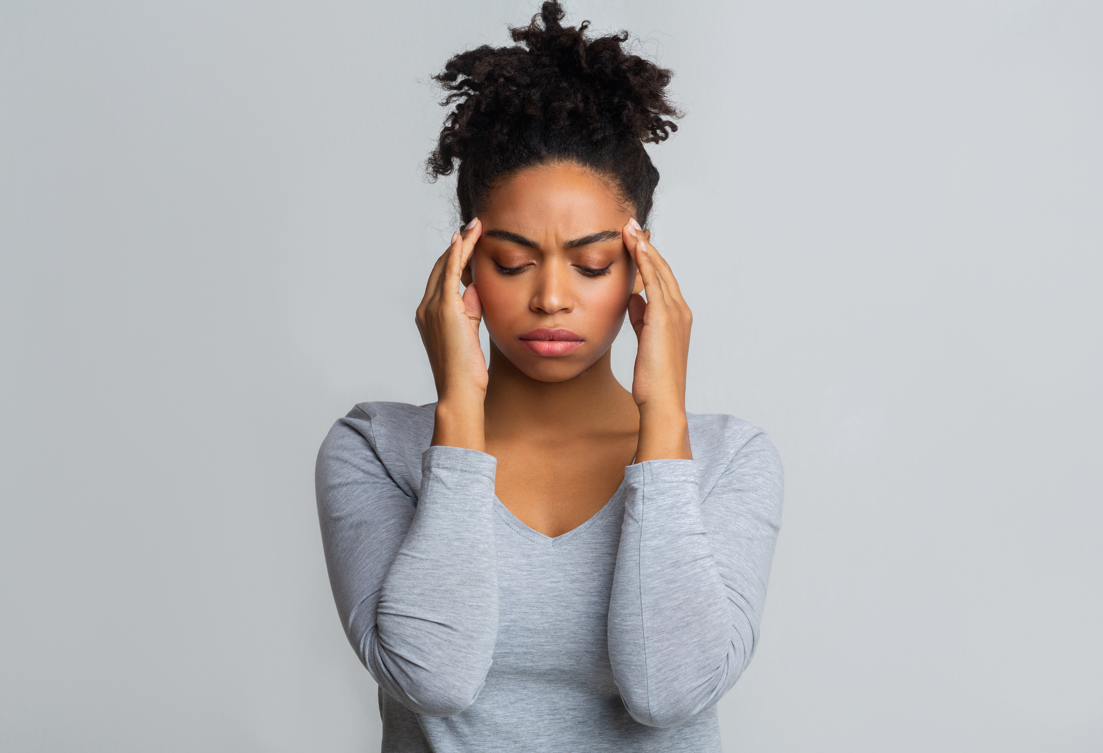 Upset black woman having headache, massaging her temples